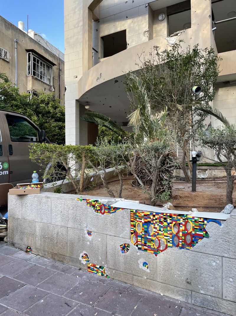 הבניין שנפגע מרסיסים, וחלקי הלגו שהודבקו. קרדיט צילום: רז שרור